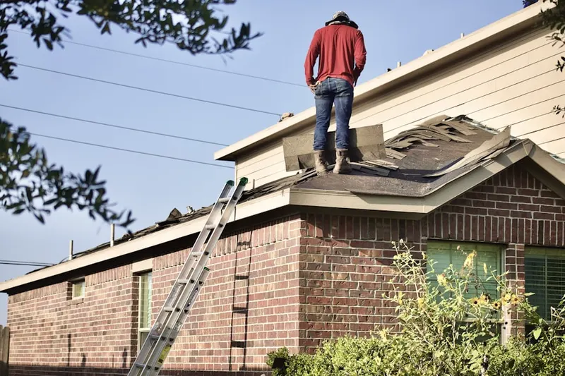Professional roofer working on a residential roof in Ontario Center